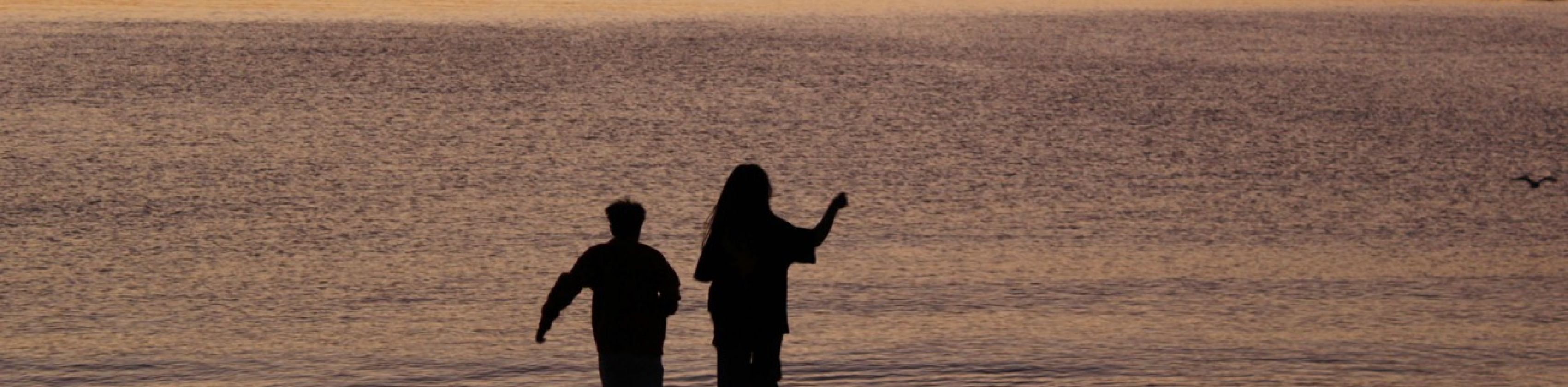 Zwei Menschen bei Sonnenuntergang am Meer, © Zuoranyi, Unsplash Zwei Menschen bei Sonnenuntergang am Meer, © Zuoranyi, Unsplash