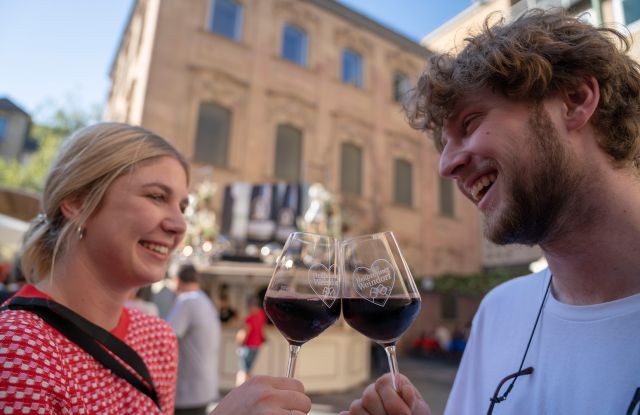 Ein Paar stößt auf der Schlenderweinprobe mit Wein an