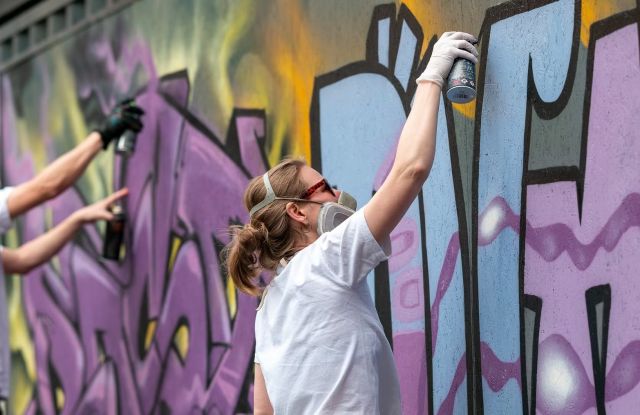 Person bemalt die Wand mit Graffiti