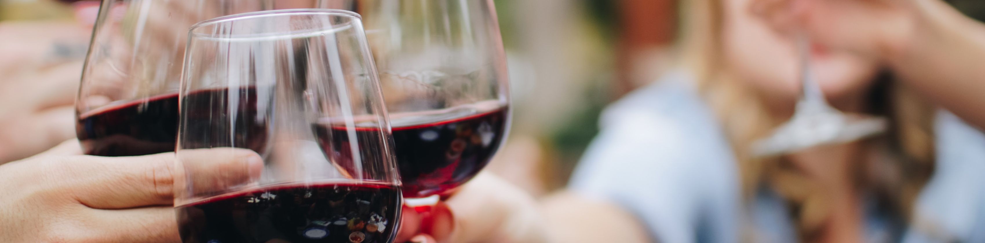 Gruppe st&ouml;&szlig;t mit Rotwein an